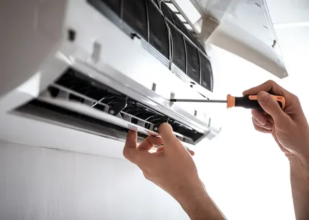 Technician replacing and repairing wall mounted air conditioning unit