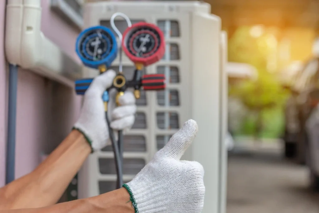HVAC technician checking AC refrigerant pressure with service gauges
